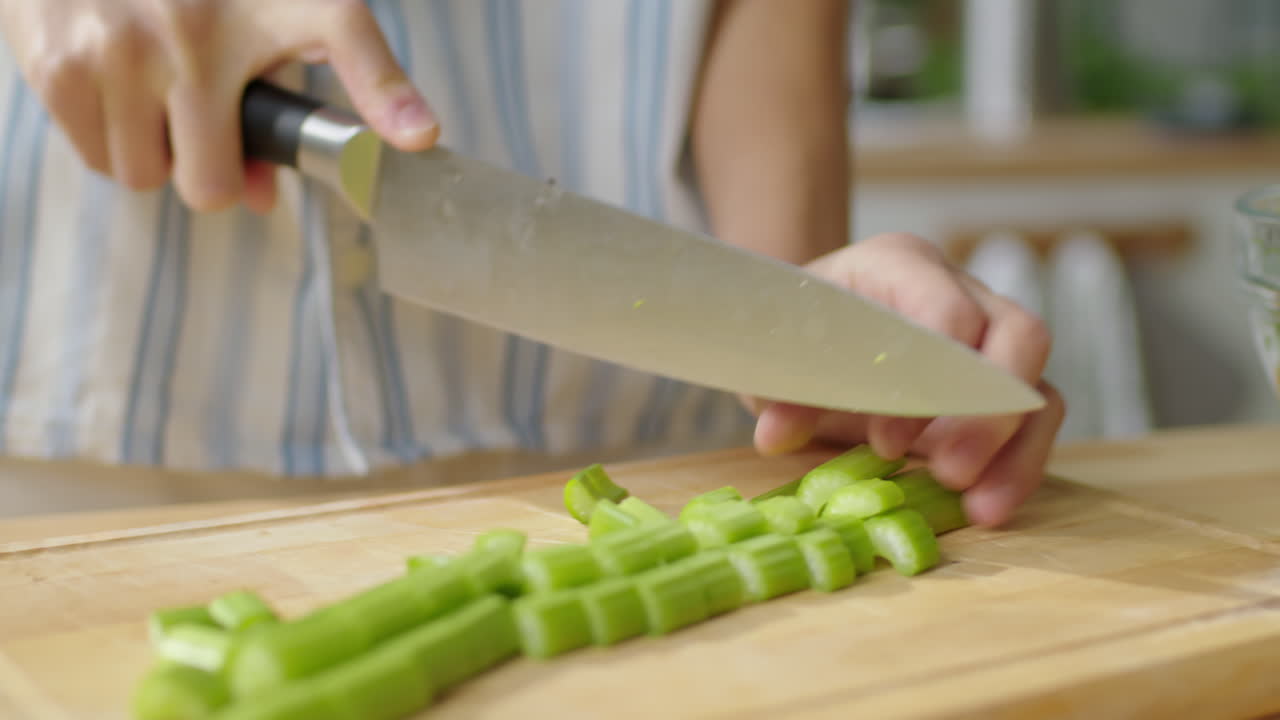 Hands of Woman Cutting Green Celery