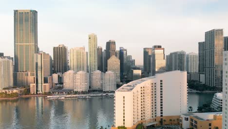 Aerial-view-of-Downtown-Miami-urban-city-center-south-of-the-Miami-River-Brickell-at-sunrise,-flying-backwards