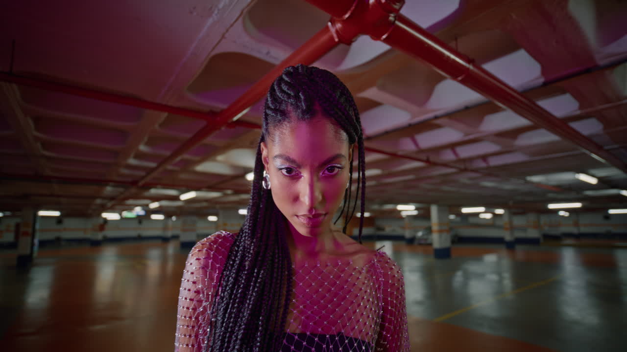 hermosa mujer de pie en el estacionamiento de neón vestido de moda en primer plano. chica joven posando