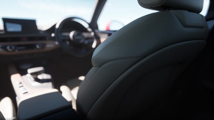 Primo piano degli interni di un'auto, che mostra i sedili in pelle, il cruscotto e il volante