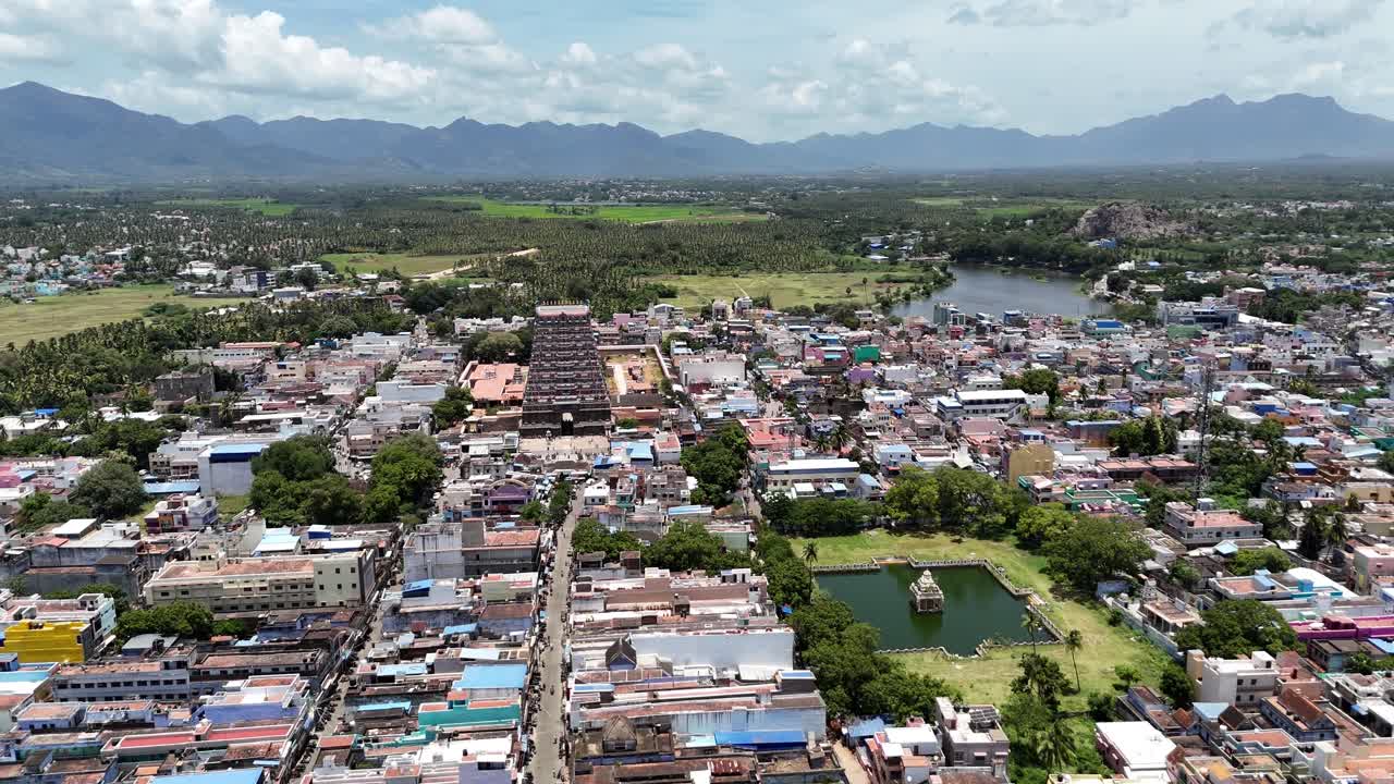 Vibrant aerial video of Tenkasi, Tamil Nadu, showcasing the towering temple gopuram, Temple Pond, lush greenery, and majestic Western Ghats beyond