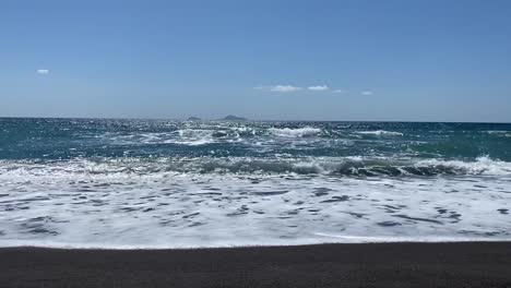 beautiful vichada black sand beach in santorini, greece on a sunny day