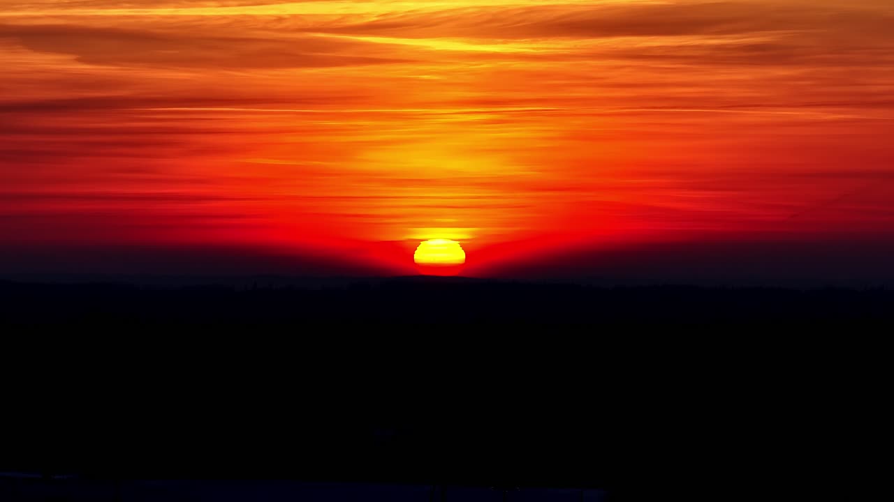 Luftfoto: ildhimmel og orange sol stiger op ved solopgang med varme farver, statisk droneoptagelse