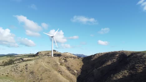 volando lejos de una sola turbina eólica en un parque eólico