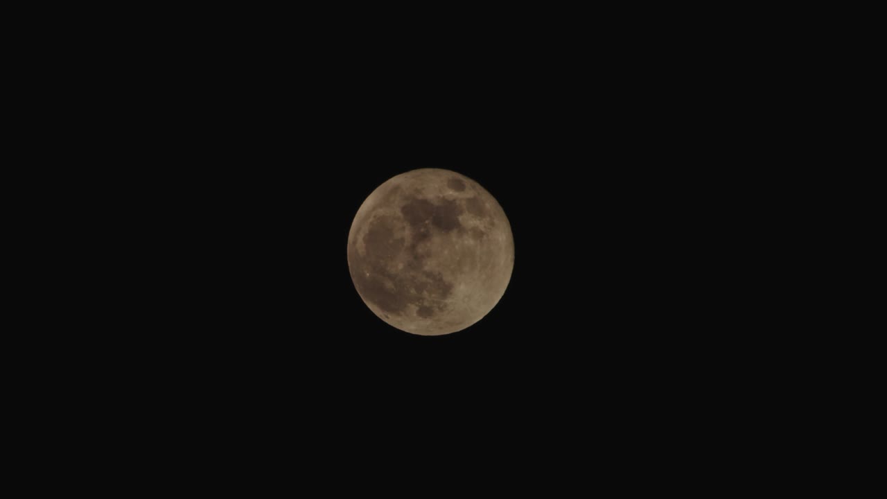 Nuvens escuras passando em frente à lua no céu noturno