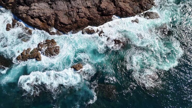 Scogliera costiera rocciosa che incontra il mare turchese