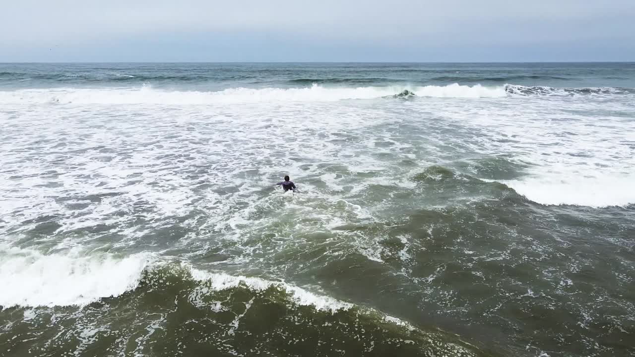 놀라운 바다 전망에서 아름다운 부드러운 파도를 타는 한 서퍼의 추월 샷