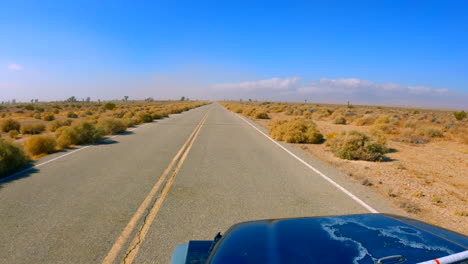 driving along a road going through the mojave desert landscape in southern california