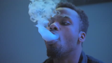 african american man blowing exhaling smoke