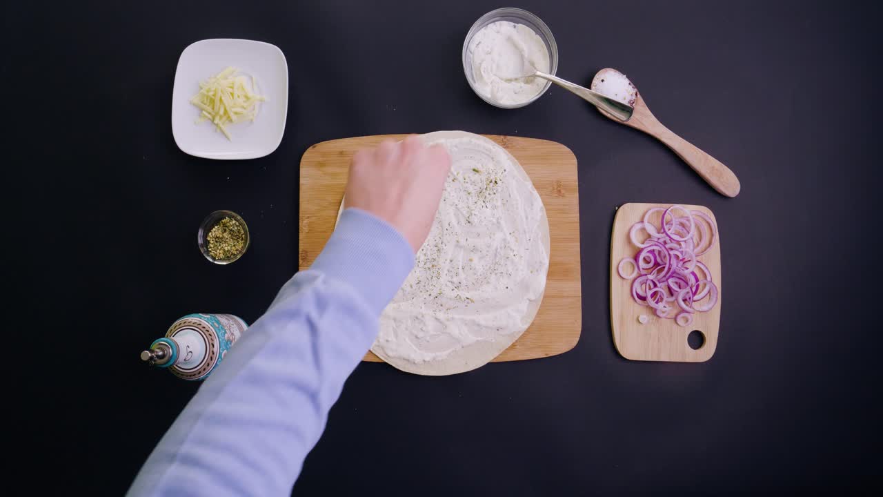 향신료, 오일, 비건 치즈와 양파를 곁들인 비건 타르트 플람베 오데르 베지타리쉬 피자를 만드는 버드아이 샷