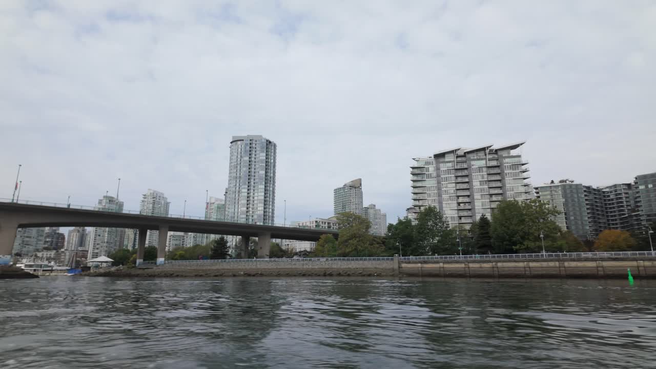 Gimbal shot from a moving boat of an Aquabus ferry heading towards Cambie Bridge on False Creek in Vancouver, British Columbia, Canada. 4K