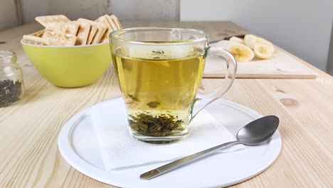 green tea with jasmine is brewed, leaves move in cup