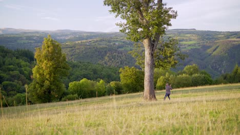 person photographing scenic landscape in a field