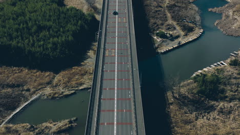 car driving along the bridge with a person fishing on whale pond near akiruno in tokyo, japan