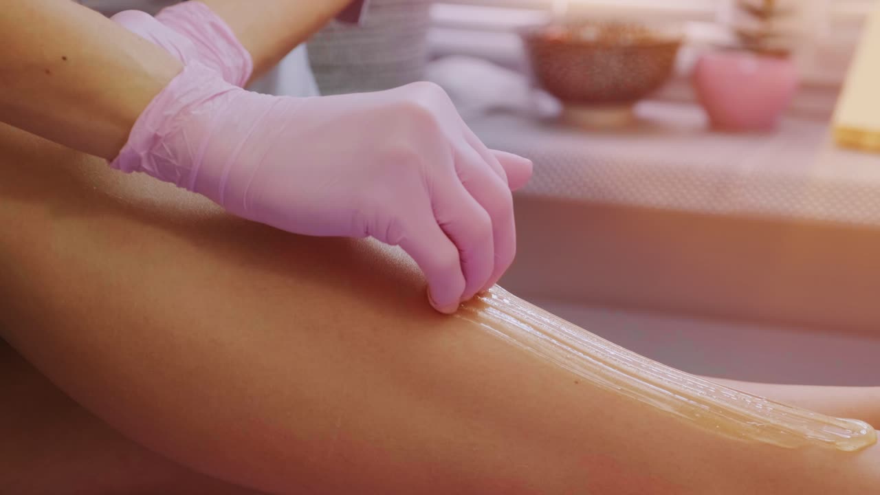 depilación de piernas femeninas con miel o pasta de azúcar. depilación de azúcar. concepto de belleza. azúcar. proceso de depilación. piernas.