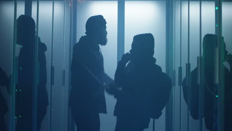 people in a server room at night