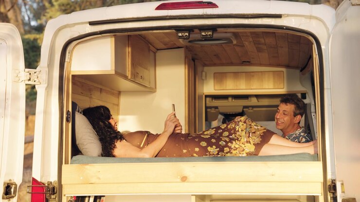 Coppia che si rilassa all'interno di un camper convertito
