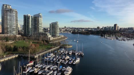 Multiple-pleasure-yachts-moored-at-scaffoldings-at-each-sides-of-the-false-creek-inlet-in-downtown-Vancouver-on-a-cloudy-day