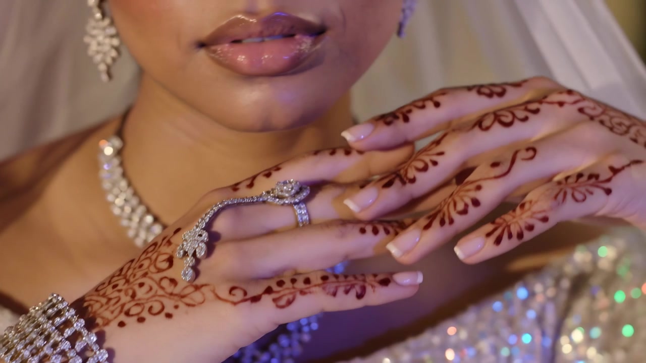 Holding hand near cheek, bride shifting hands showcasing henna and hand-harness, veil in studio