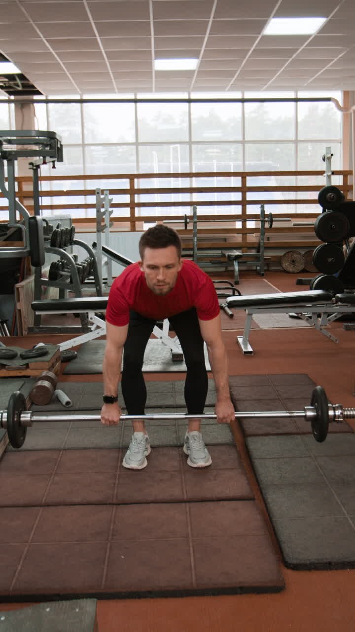 Man performing deadlift exercise in a gym