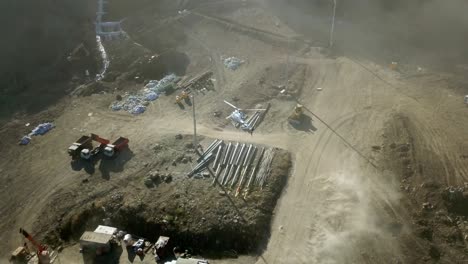 helicóptero que transporta materiales de construcción sobre el sitio de construcción vista desde un dron volador. helicóptero industrial participa en la construcción y ayuda a transportar pilares por aire