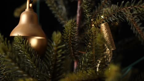 Christmas-jingle-golden-bell-hanging-on-a-tree,-sliding-shot