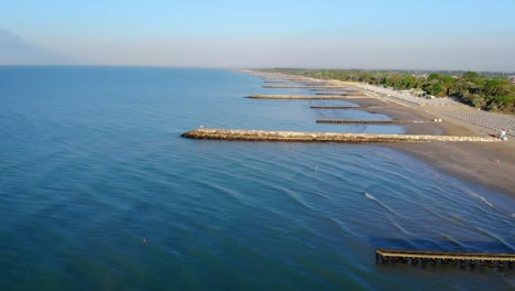 Drone-Paisaje-Marino-A-Lo-Largo-De-La-Playa,-Embarcadero,-Gente,-Vista-De-Largo-Alcance,-Sobre-El-Agua