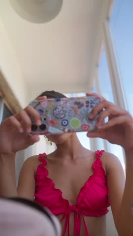 young woman holding smartphone with colorful case