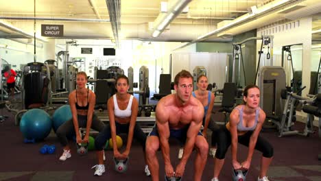 instructor muscular que dirige la clase de kettlebell