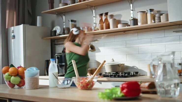 Donna che balla e cucina in cucina