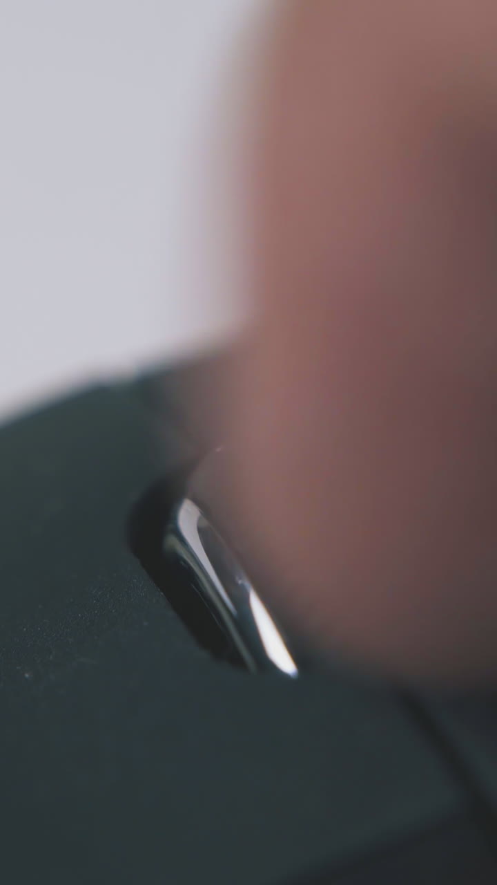 young person turns wheel of modern wireless computer mouse on white background extreme close view