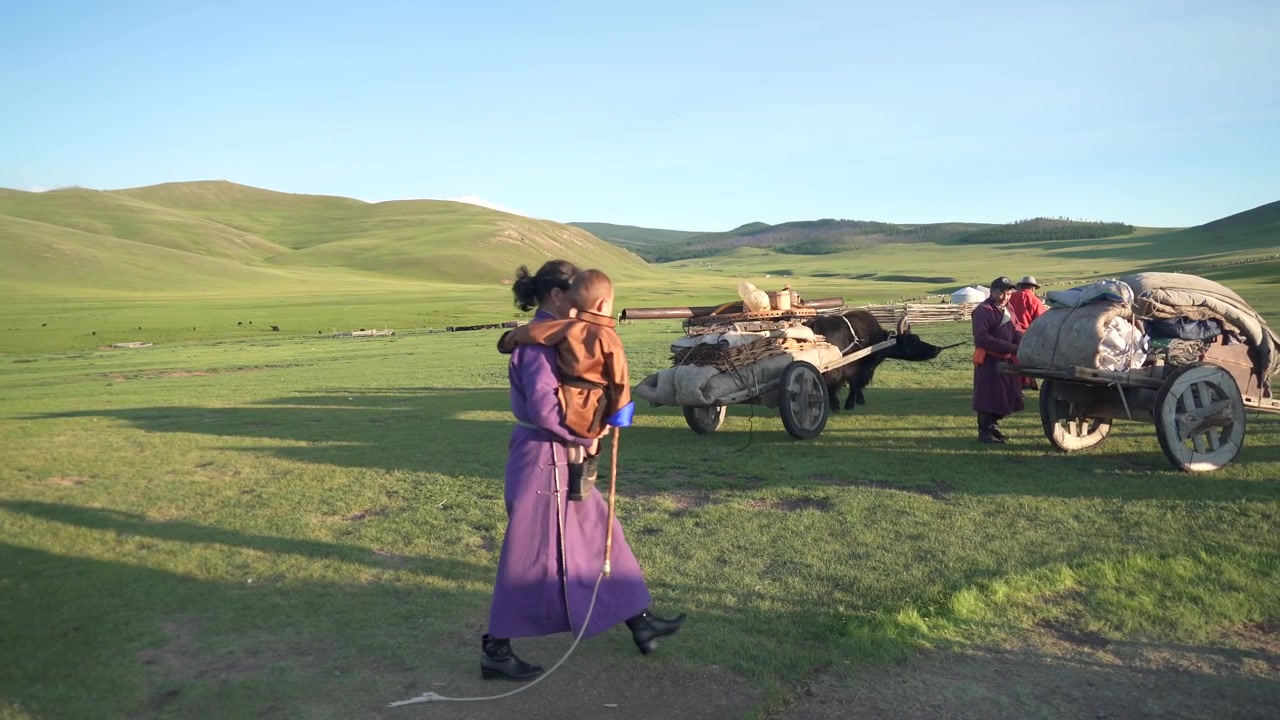 Mongolsk nomadefamilie med yakoksevogn på græsland