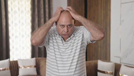 Fat-Indian-old-man-suffering-from-severe-headache