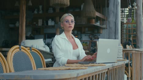 woman working on laptop in outdoor cafe
