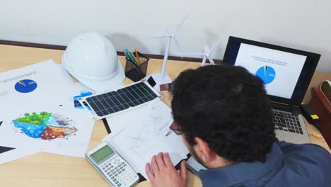 engineer working at a busy desk on a sustainable project