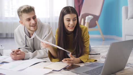 Young-student-couple-studying-at-home-talking-with-friends-on-video-chat-on-laptop