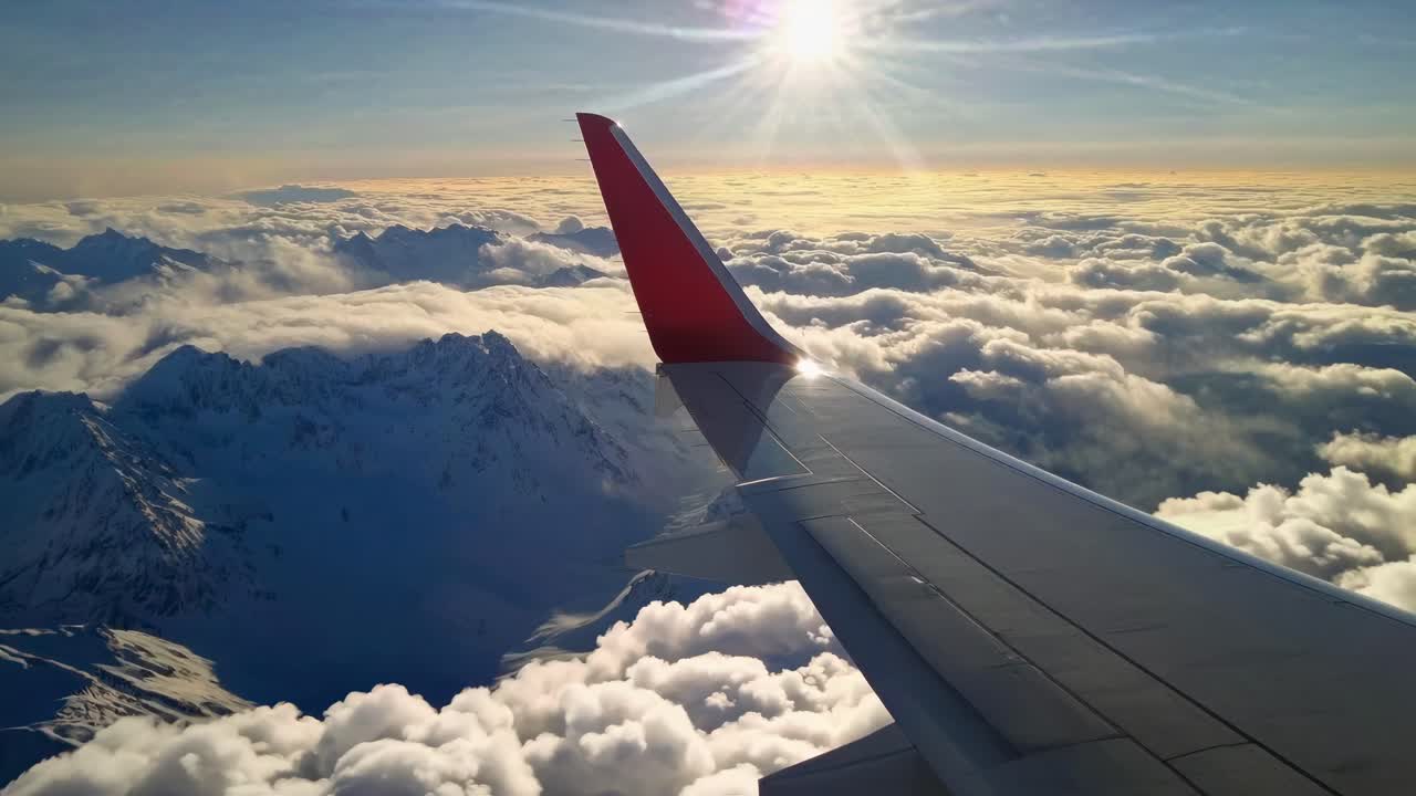Vídeo aéreo capta el ala de un avión sobre montañas nevadas al amanecer