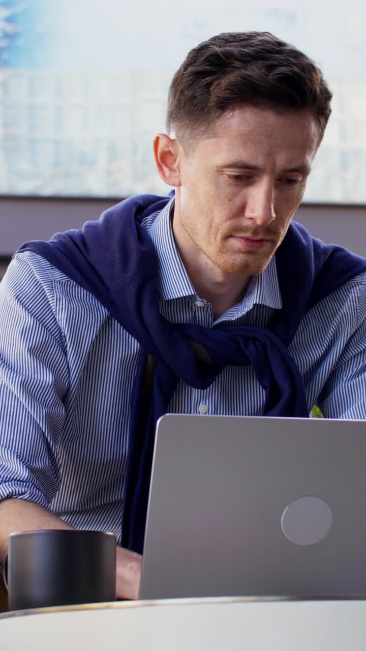 un hombre trabajando en una computadora portátil en un café