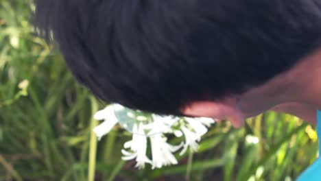 cute boy looking at grass with a magnifying glass