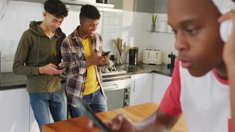 video of happy diverse male teenage friends using smartphones, slow motion