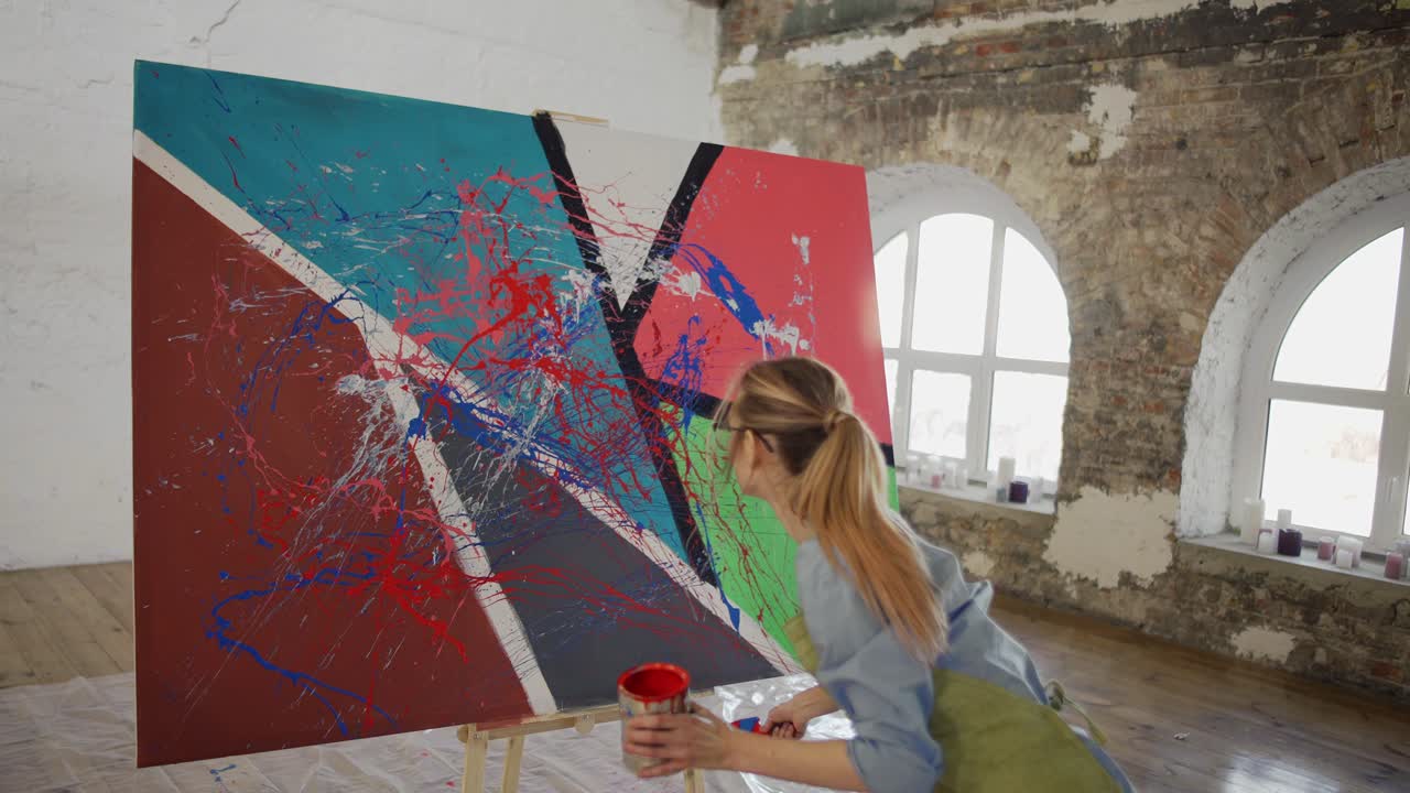 artista femenina crea emocionalmente una obra maestra de pintura abstracta en el estudio, en cámara lenta