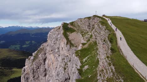 seceda at urtijei, south tyrol, italian alps, dolomites, italy - aerial drone view of hiking path to the top of the mountain peak