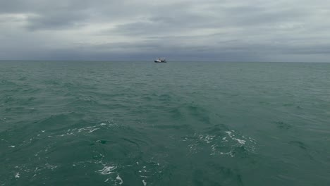 Ein-Fischerboot-Am-Horizont-Versteckt-Sich-Hinter-Einer-Großen-Dünung-Im-Meer