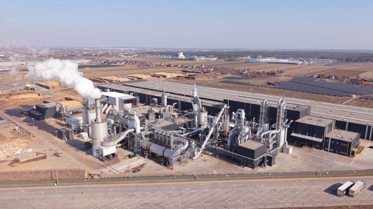 Aerial Energy Plant Releasing White Steam Plume Above Stacks, Industrial Units And Long Processing Lines Visible, Remote Monitoring And Compliance Context With Clear Sky Background