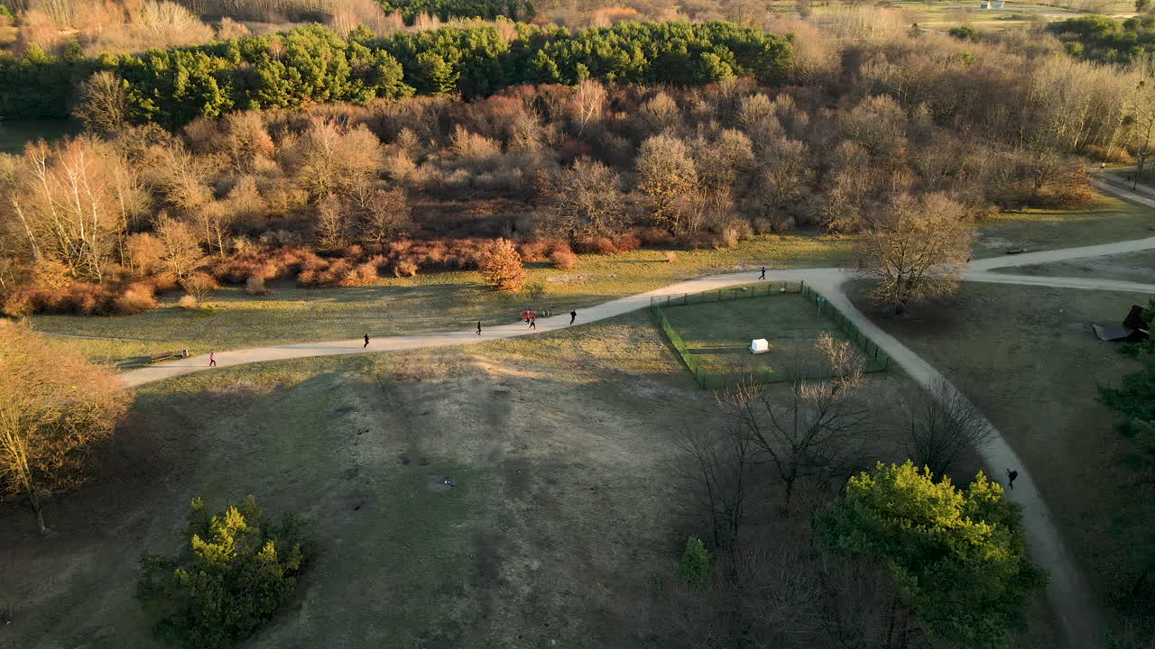 People jogging in the autumn landscape at sunrise - Aerial panning, Gdansk Przymorze Poland