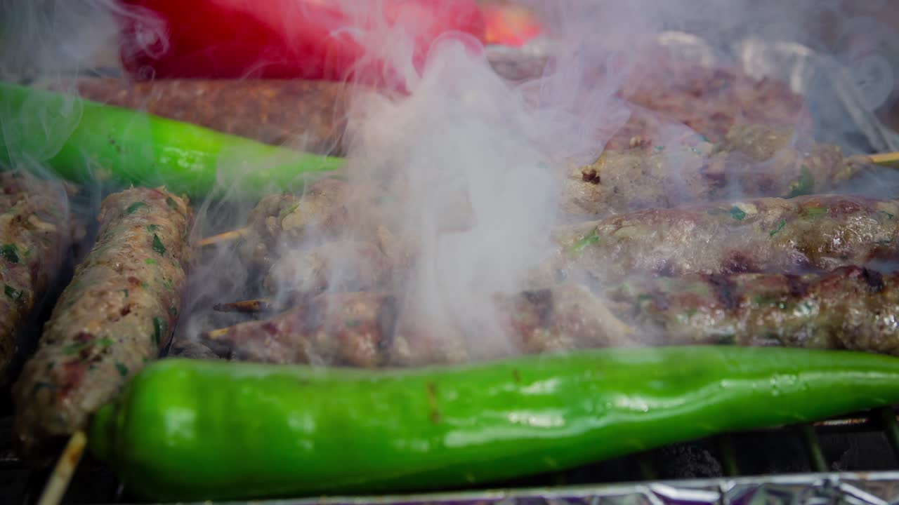 Cinemagraph di fumo emesso dalla cottura di diversi tipi di carne su una griglia BBQ calda