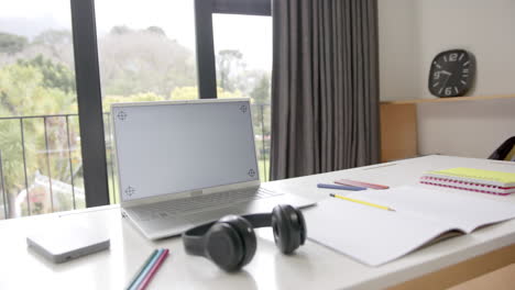 primer plano de la computadora portátil con espacio de copia en la pantalla y auriculares en el escritorio, cámara lenta