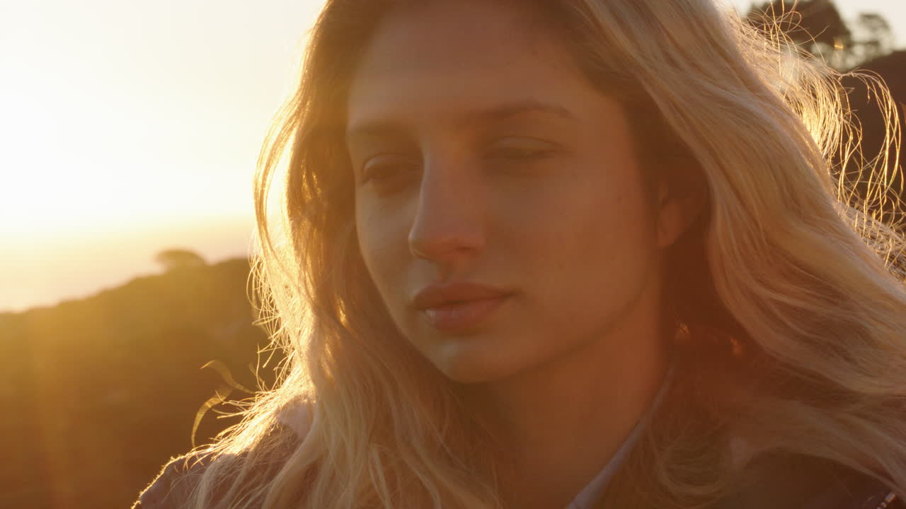 retrato de una mujer feliz riendo divirtiéndose en las vacaciones de verano disfrutando de la playa al atardecer con el viento soplando el cabello