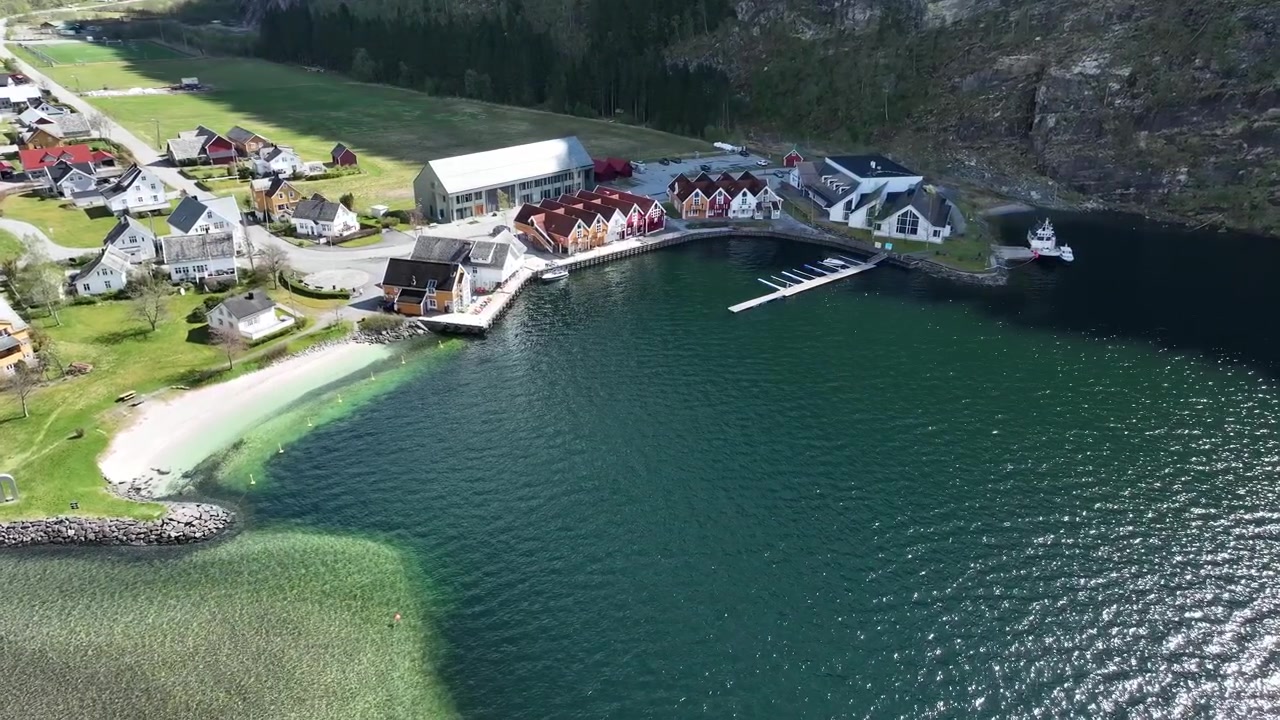 Dorfzentrum Mo in Modalen, Norwegen, mit Yachthafen, Strand und Uferpromenade an einem sonnigen Frühlingsmorgen