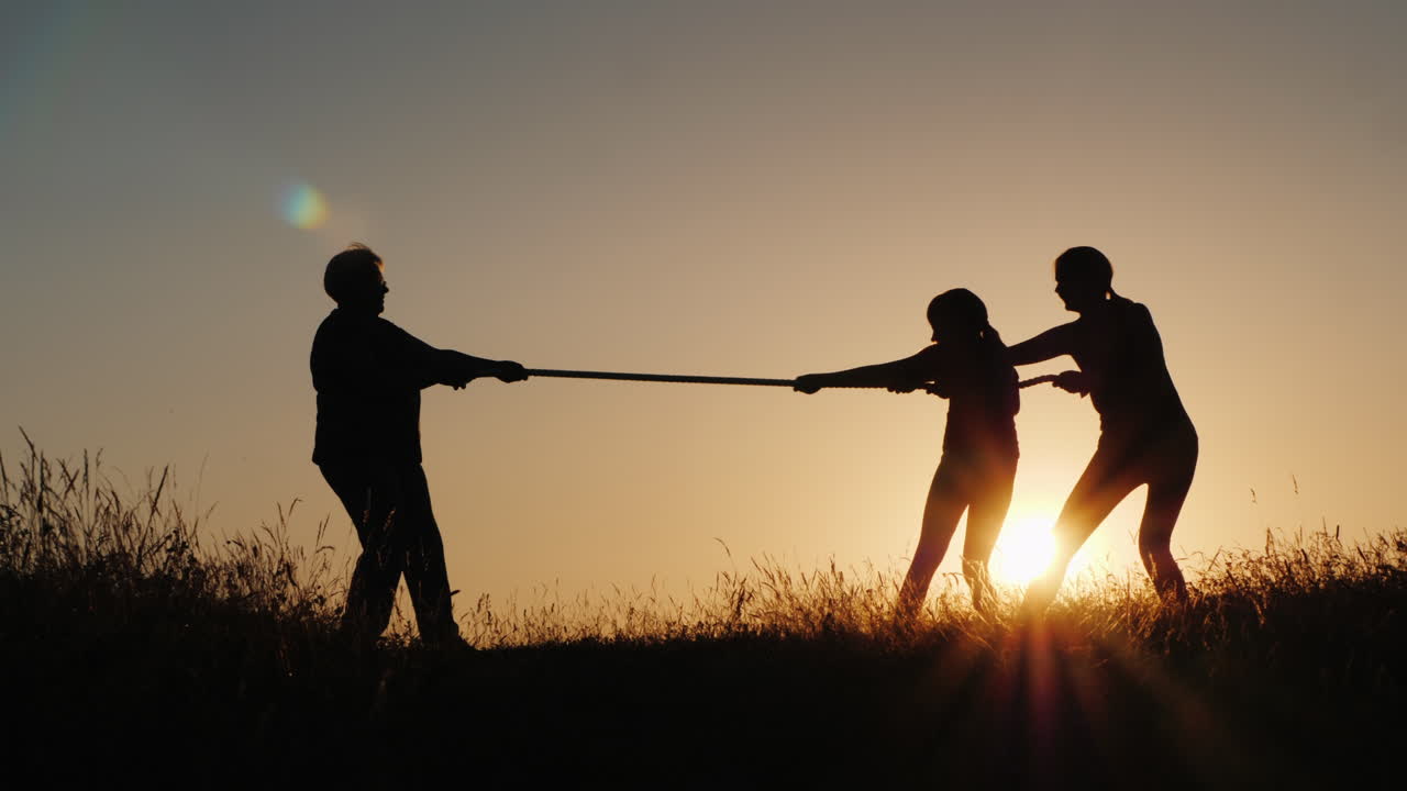 A Strong Older Woman Is Competing With Young People In Tug-Of-War Active Elderly People